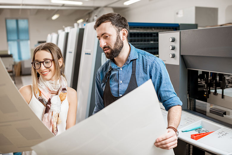 Woman with print operator at the printing manufacturing.